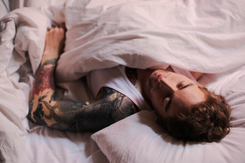 Man Lying on Bed With Tattoo on His Body